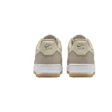 Championes Nike Air Force 1 de corte bajo, color blanco con detalles en textura de piel de serpiente en tono bronce en el swoosh lateral y en el talón.