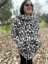 Buzo color beige de poliéster con textura de piel de oso, capucha con cuello alto, mangas largas y bolsillo tipo canguro.