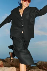 Bermuda negra de lino y rayón con elástico en la cintura, largo a media pantorrilla, tiro bajo y fit oversized en A.