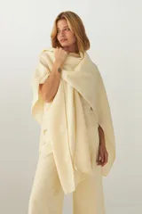 Ruana de lana fina sin teñir, con textura acanalada y terminaciones tejidas a crochet hechas a mano.