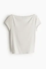 Remera corta color crudo, de punto acanalado transparente, con escote barco y mangas cortas.