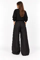 Pantalon de lino negro de corte wide leg, con cintura alta definida, pinzas frontales y bolsillos laterales.