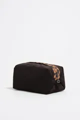 Neceser de tamaño grande con estructura blanda, exterior de nylon negro y asa superior con estampado de leopardo. Presenta el logo metálico de Bimba y Lola en el frente.