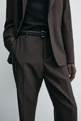 Pantalón de corte recto confeccionado en tejido con lana, color beige. Presenta bolsillos frontales, bolsillos traseros de vivo y cierre frontal con cremallera y botón.