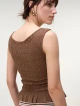 Musculosa de algodón color negro con escote bote, diseño con nido de abeja elástico y terminación con pequeño vuelo en el ruedo.