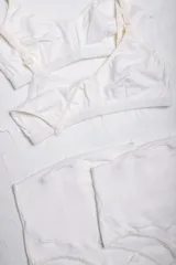 Pack de maternidad compuesto por dos soutienes de lactancia con broches frontales y dos bombachas de tiro alto con faja de sujeción. Confeccionado en algodón suave de color crema con detalles de puntilla en las piernas.