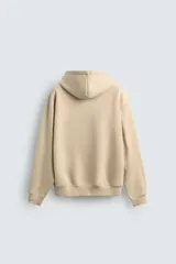 Sudadera tipo hoodie de corte relajado, confeccionada en tejido de algodón con interior cepillado. Presenta capucha con cordones ajustables, bolsillo frontal tipo canguro y terminaciones en rib en puños y ruedo.