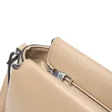 Bandolera de color taupe confeccionada en cuero sintético con textura granulada. Presenta un diseño rectangular con compartimento principal y bolsillo interno con cierre. Incluye una correa regulable y desmontable con herrajes metálicos en color níquel y el logo XL aplicado en el frente.