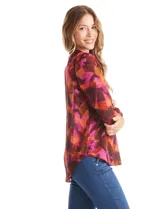 Blusa de gasa con estampado abstracto en tonos marrones, naranjas y fucsias. Presenta cuello mao con escote en V y mangas largas con sistema de ajuste mediante presilla y botón.