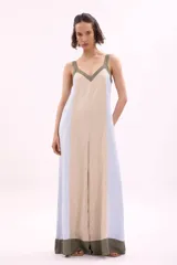 Mono palazzo color beige con terminaciones en negro, escote en V y tirantes anchos.