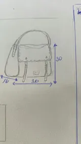 Bandolera tipo messenger bag confeccionada artesanalmente en combinación de cuero y gamuza marrón. Cuenta con solapa frontal de cuero con broches a presión, correas decorativas con hebillas metálicas y una correa larga ajustable para el hombro. Incluye parche con logo grabado en la parte frontal.