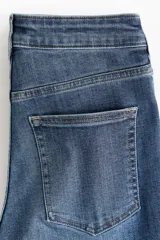 Jean skinny de tiro alto en denim azul con efecto deslavado y leve elasticidad, corte ajustado de cadera a tobillo, con diseño clásico de cinco bolsillos y cierre frontal con botón y cremallera.