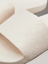Ojotas Calvin Klein con tira ancha de tejido jacquard que presenta el logo de la marca en relieve. Poseen plantilla ergonómica moldeada con soporte para el arco y suela de EVA.