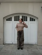 Sweater corto color beige, de cuello alto y tejido de punto acanalado.