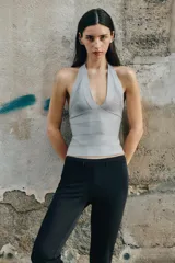 Top de tejido elástico con diseño de bandas horizontales, cuello halter y profundo escote en V.