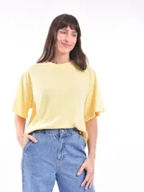 Remera oversize de color amarillo pastel, con cuello redondo y mangas cortas de corte holgado.