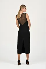 Vestido midi negro con escote transparente y detalle de lentejuelas en el borde del escote.