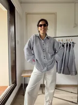 Camisa oversize a rayas verticales blancas y negras con bordado rojo en el frente.