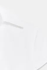 Top de popelina blanca de corte corsetero, con escote en pico pronunciado, cuello tipo solapa, mangas muy cortas y costuras marcadas.