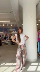 Pantalón de jean wide leg tiro medio con diseño de rayas verticales en tonos azul, rojo, amarillo y blanco. Presenta recortes y pespuntes a contratono.