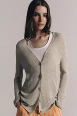 Chaqueta de punto color beige con escote en V, manga larga y cierre frontal con botones dorados.