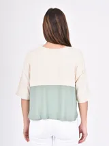 Remera de corte oversize con diseño en bloque de color, combinando tonos rosado claro y bordó, de mangas cortas y cuello redondo.