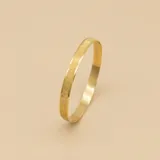 Esclava rígida de oro 18k con acabado satinado y diseño de cinta plana. Presenta una textura fina y elegante en toda su superficie.