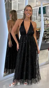 Vestido largo negro de fiesta con escote halter profundo y espalda descubierta, confeccionado en tul con delicado bordado de lentejuelas y abalorios colgantes en todo el diseño.