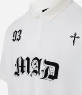 Remera de corte boxy confeccionada en algodón, con cuello polo y cierre frontal de botones. Presenta un diseño estampado en el frente con el número 93, una cruz y la palabra MAD en tipografía gótica.