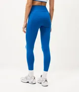 Pantalón legging deportivo Get Over de color azul, confeccionado en microfibra con cintura alta y ancha, recortes anatómicos y bies contrastante blanco a los lados.