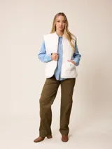 Chaleco acolchado de diseño matelassé con cierre frontal completo, cuello tipo bomber y bolsillos laterales. Presenta un pequeño bordado decorativo en la parte inferior.