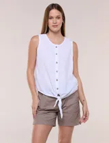 Blusa blanca sin mangas, confeccionada en algodón con sutiles rayas verticales en relieve. Presenta cuello redondo, cierre frontal con botones de madera y un nudo ajustable en el dobladillo delantero.