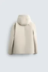 Cazadora técnica regular fit de color negro, con interior ligeramente acolchado. Presenta cuello subido con capucha ajustable, cierre frontal de cremallera oculta por solapa con botones a presión, bolsillos laterales y puños con interior de rib.