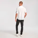Camisa de manga larga convertible, color blanco, confeccionada en popelina. Cuenta con cuello clásico, cierre frontal con botones, bolsillo en el pecho con etiqueta de marca y mangas enrollables con pestaña de ajuste.
