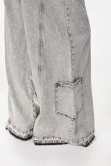 Jean wide leg de tiro alto en color gris con efecto acid wash, bolsillos funcionales, costuras marcadas y ruedo desflecado.