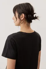 Remera de manga corta color negro, de corte clásico y escote en V, con sutil detalle bordado en el pecho.
