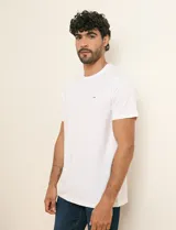 Remera básica de color blanco, de manga corta y cuello redondo con ribete, corte recto y detalle de etiqueta pequeña en el pecho.