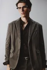 Blazer de corte relajado confeccionada en mezcla de algodón con acabado efecto lavado. Presenta cuello con solapas de muesca, cierre frontal con dos botones, bolsillo de vivo en el pecho y bolsillos con solapa en la cadera. Diseño sin forro interior con aberturas en la espalda.