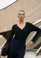 Mono largo de diseño combinado, con parte superior de tejido de punto acanalado con cuello en pico y cierre frontal de botones, y parte inferior de pantalón de corte recto. Cuenta con manga larga y bolsillos laterales.