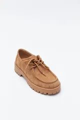 Zapato de gamuza color marrón con cordones, puntera con costura marcada y suela robusta dentada.