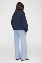 Buzo oversize blanco de algodón, con cuello redondo, mangas largas con hombros caídos y estampado gráfico collegiate en el pecho.