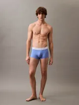 Pack de tres bóxers tipo trunk Calvin Klein Modern Air de tiro bajo, confeccionados en malla perforada transpirable con mezcla técnica elástica. Incluye un bóxer negro, uno celeste y uno blanco, todos con cintura elástica con logo de la marca.