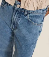 Pantalón de jean azul oscuro con corte recto, cintura con trabillas, cierre de botón y cremallera, y bolsillos delanteros y traseros.