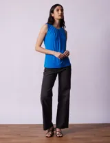 Musculosa negra de poliéster y elastano, con cuello redondo con frunces delanteros y abertura con botón en la espalda.