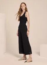 Pantalón negro de tejido de punto con corte recto, cintura alta, aberturas laterales y acabado acanalado.