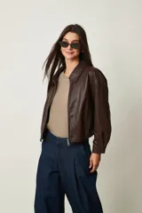 Campera corta de cuero sintético marrón, con cuello camisero y cierre frontal.
