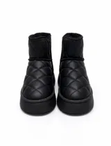 Botas tipo pantubota de caña baja, color negro, con diseño acolchado en forma de rombos y suela de plataforma plana. Presentan interior forrado en piel sintética y detalle de etiqueta en el lateral.