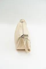 Cartera tipo bandolera de tela con diseño semicircular, cuenta con una correa larga ajustable y cierre superior.