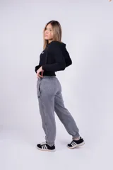 Pantalón de jogging gris con efecto lavado, corte holgado y logo bordado en negro.