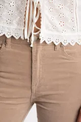 Pantalón de pana color beige, tiro medio, corte recto y largo al tobillo.